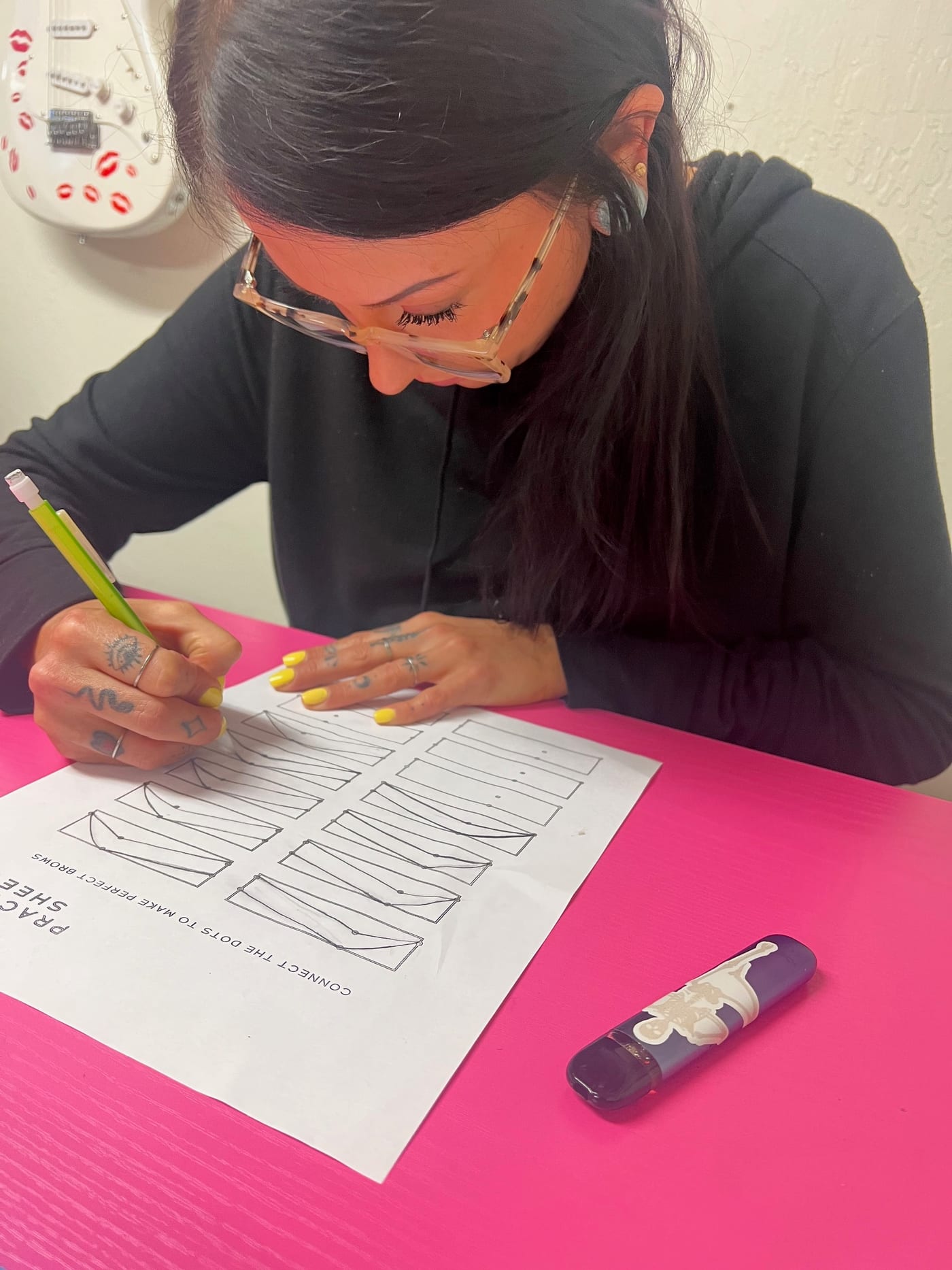 A student mapping a brow shape before working on a model